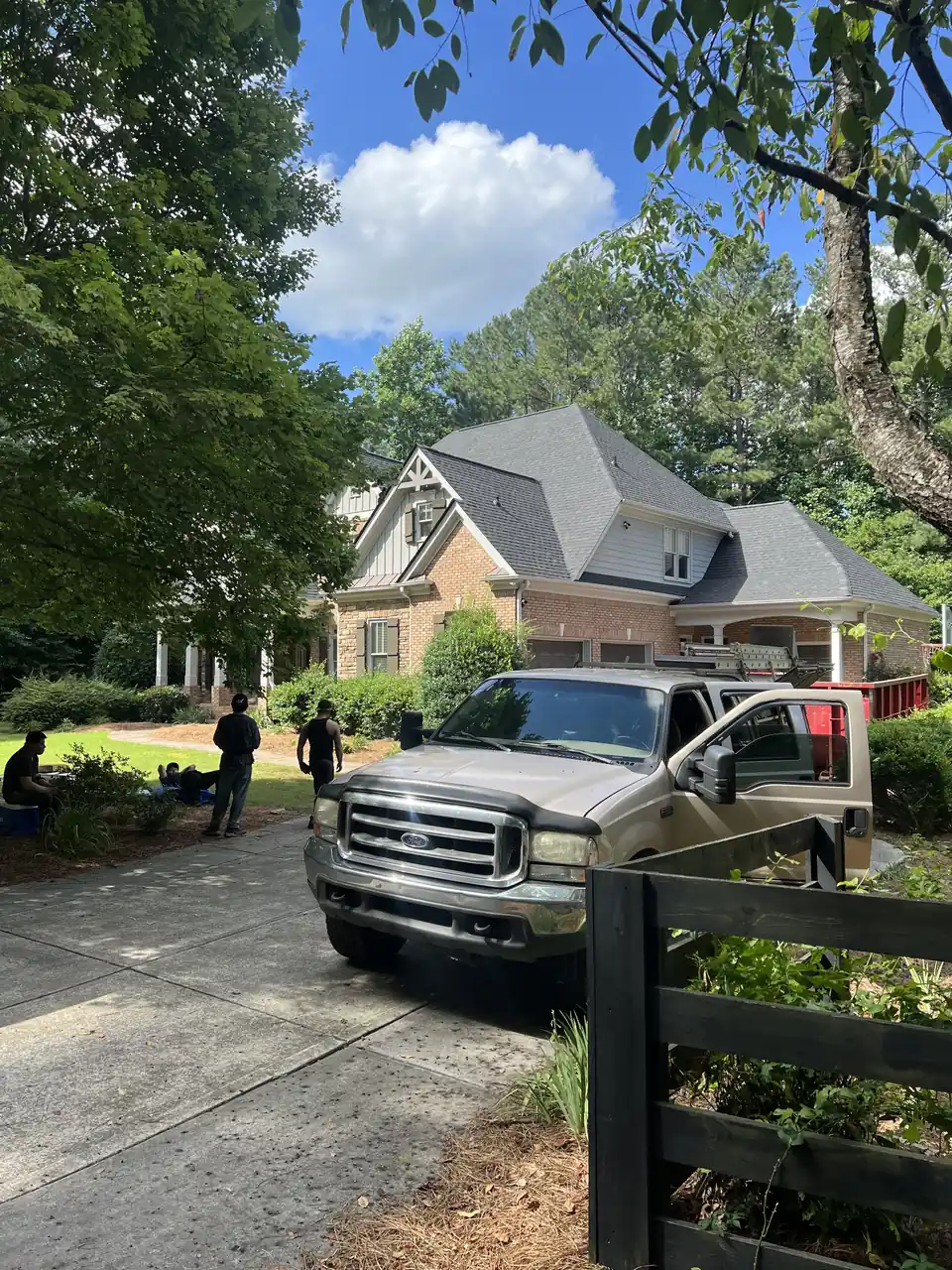 Atco Roofing crew and truck at a Covington brick home