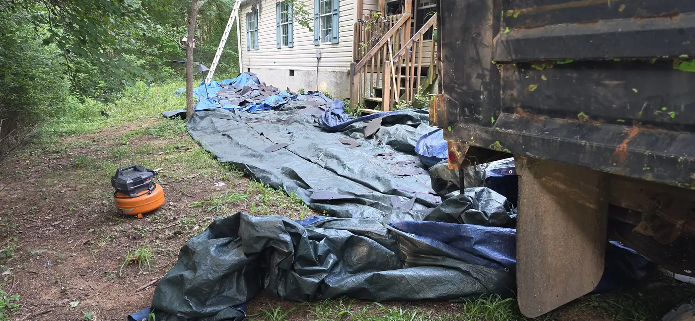 Tarps protecting the yard during a roof tear-off