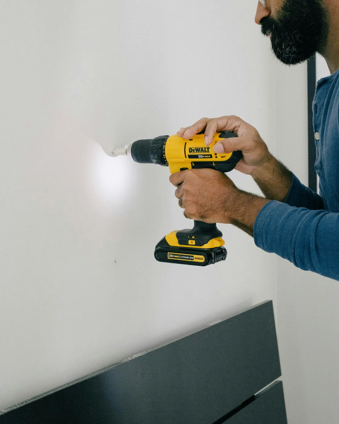 Installer fastening a new drywall panel with a screw gun