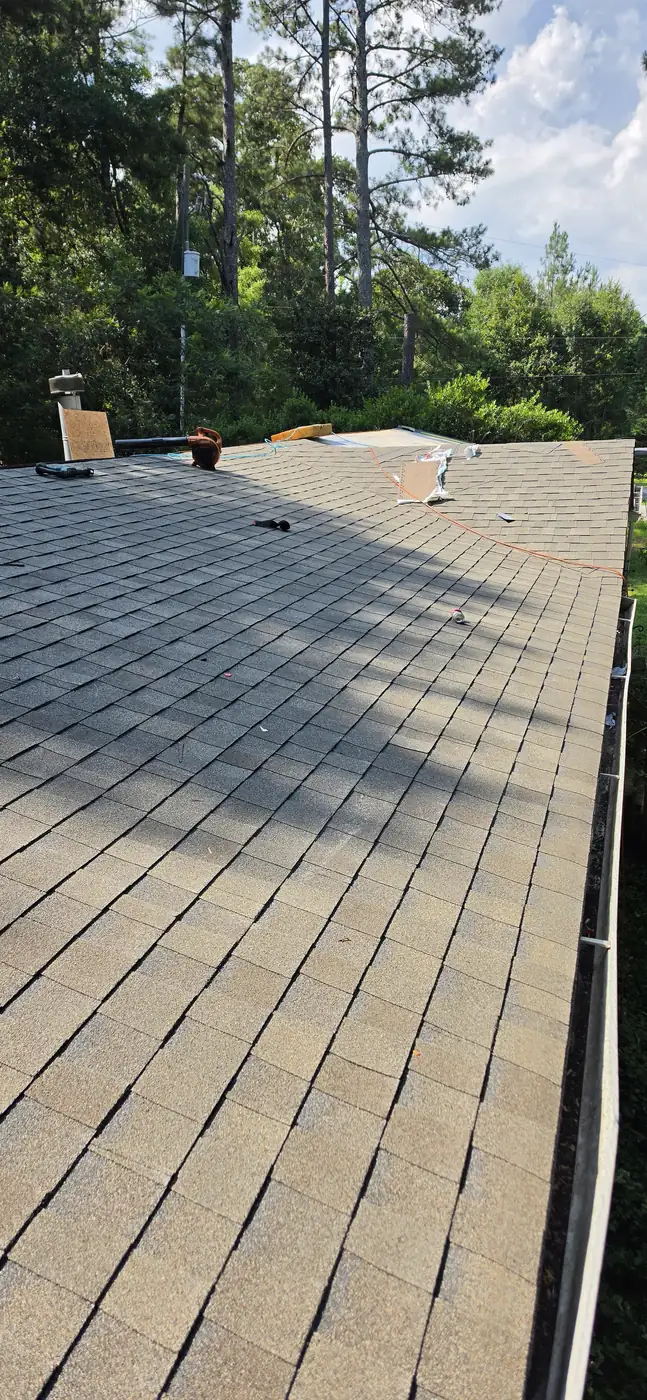 Finished asphalt shingle roof running up to a chimney