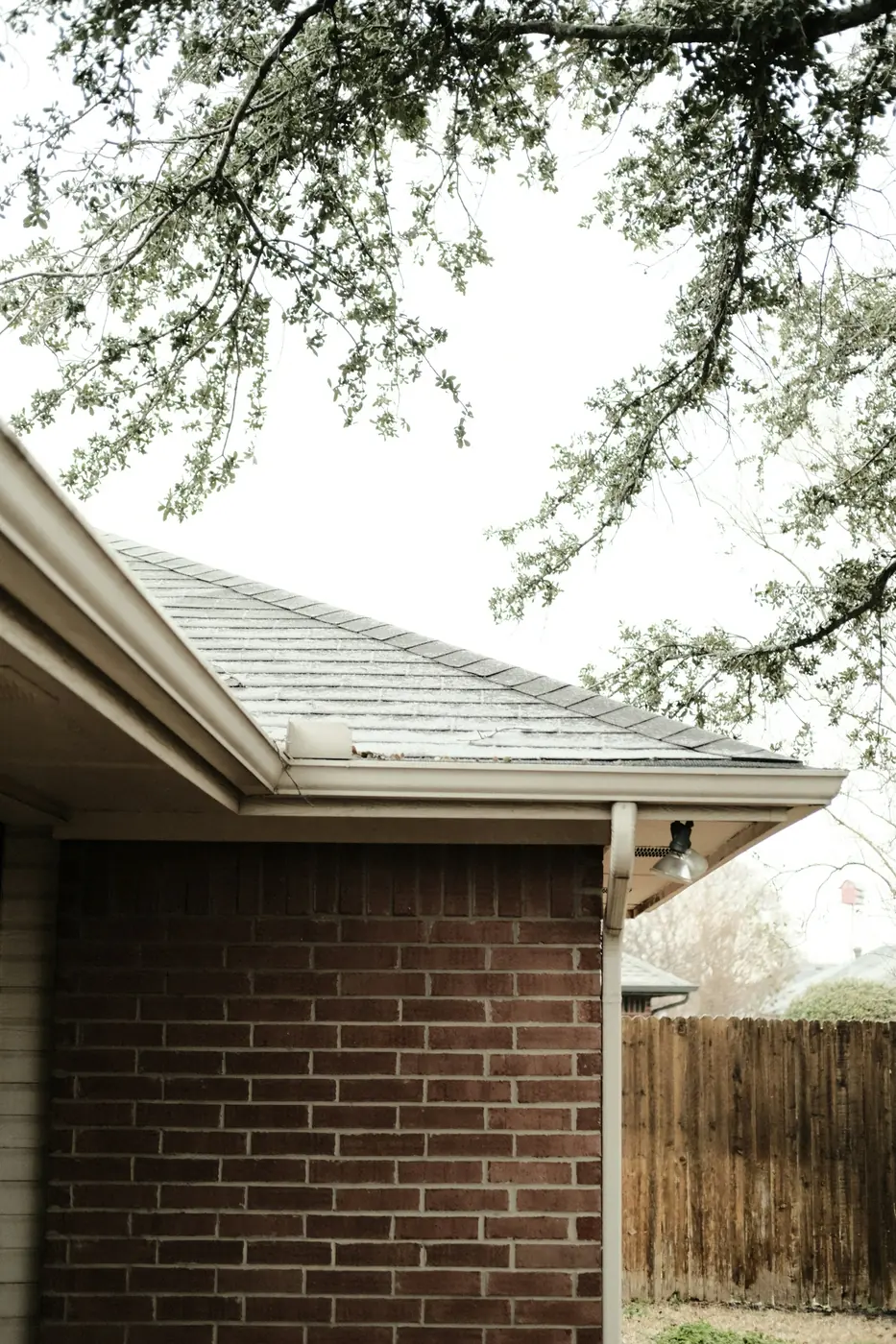Gutter and downspout on the corner of a brick home