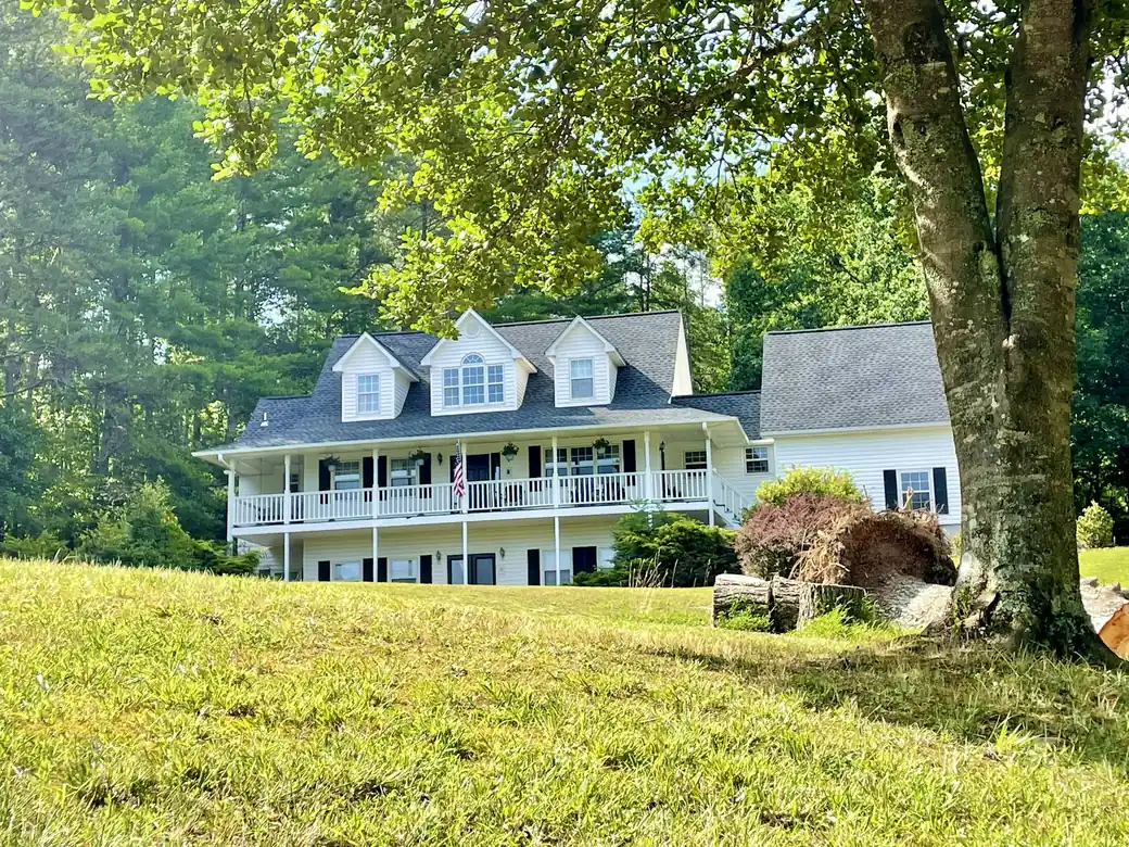 White Southern farmhouse with a wraparound porch
