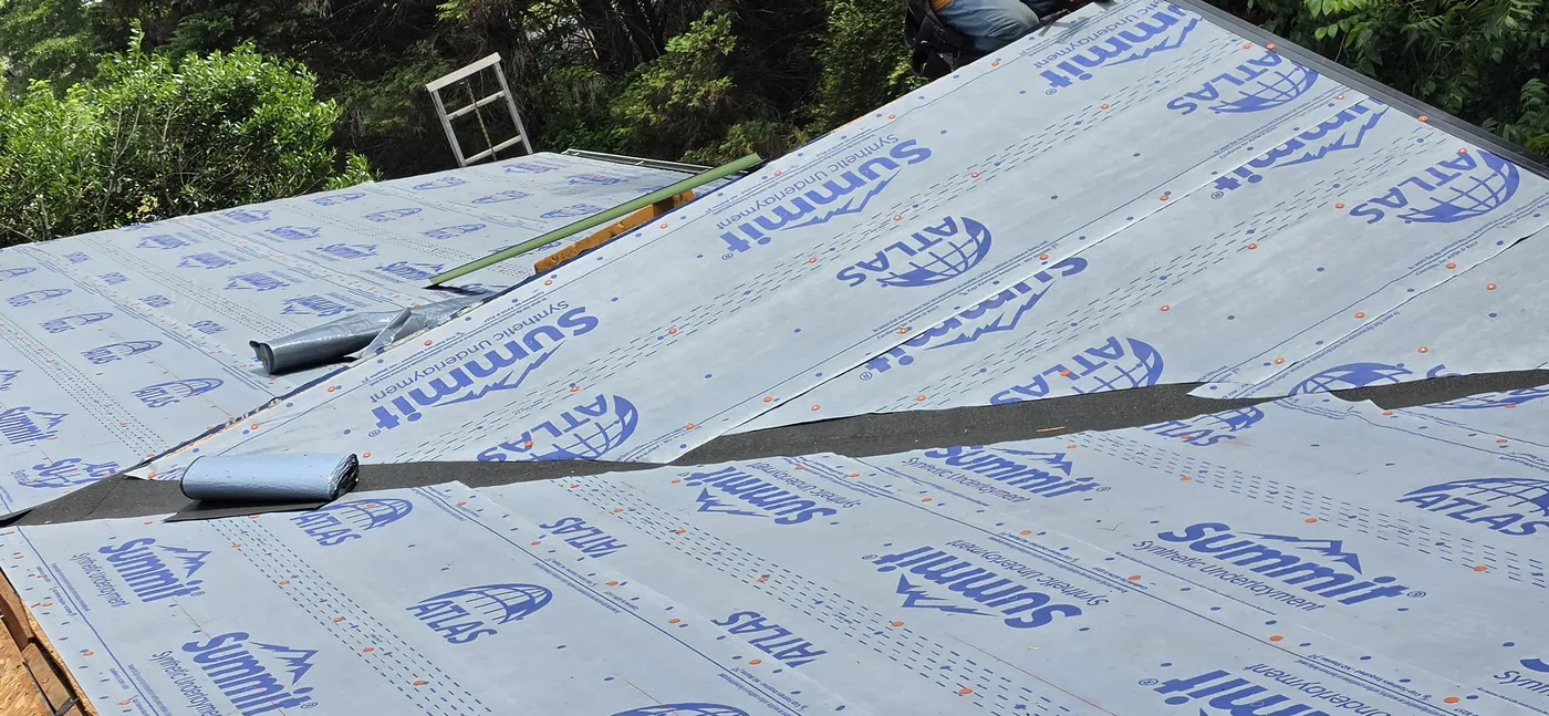 Synthetic underlayment installed over decking before new shingles